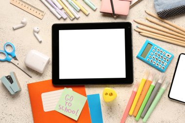 Yazılı yapışkan not Go to SCHOL, aygıtlar ve grunge beyaz arkaplan üzerinde farklı kırtasiye