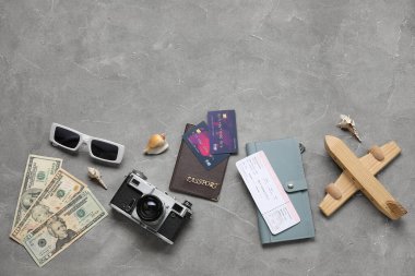 Kredi kartı, bilet, fotoğraf makinesi ve grunge arkaplanda güneş gözlüğü olan kompozisyon