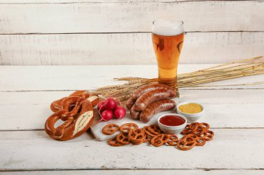 Hafif ahşap arka planda farklı aperatiflerle soğuk bira ve yiyecek. Ekim Festivali Kutlaması