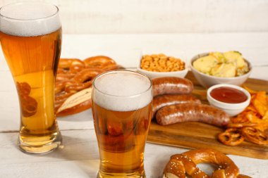 Soğuk bira bardakları ve hafif ahşap arka planda farklı atıştırmalıklar. Ekim Festivali Kutlaması