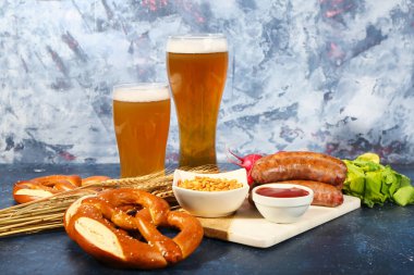 Soğuk bira bardakları ve mavi arka planda farklı atıştırmalıklar. Ekim Festivali Kutlaması