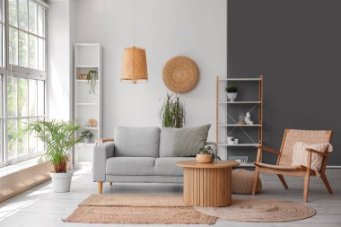 Gri kanepesi, kahve masası ve koltuğu olan bir oturma odası.