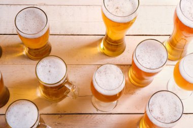 Hafif ahşap arka planda soğuk bira bardakları ve kupaları. Ekim Festivali Kutlaması