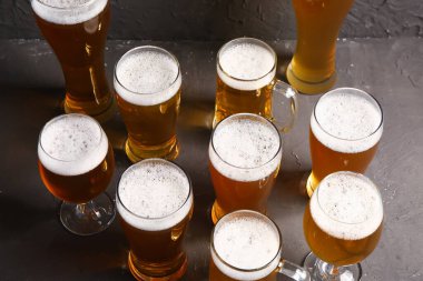 Siyah arka planda soğuk bira bardakları ve kupaları. Ekim Festivali Kutlaması