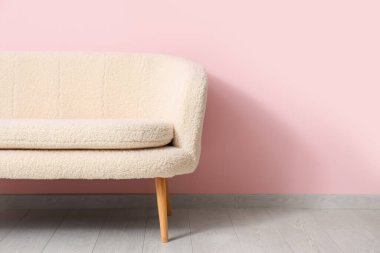 Pembe duvarın yanındaki rahat beyaz kanepe