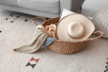 Oturma odasında şapka ve battaniyeli bir sepet.