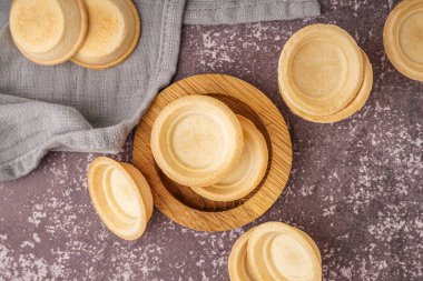 Gri arka planda ev yapımı tartlarla dolu bir kase