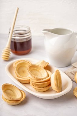 Gri arka planda ev yapımı tartlarla dolu bir kase