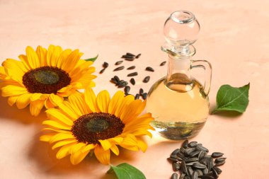 Bej arka planda ayçiçekleri, tohumlar ve sürahi yağ