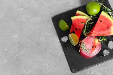 Lezzetli karpuz kokteyli, limon ve buz küpleri ve grunge grisi arka planda.