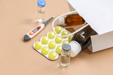 Kahverengi arka planda farklı ilaçlarla alışveriş torbası.