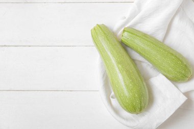 Beyaz ahşap arka planda taze yeşil kabak.