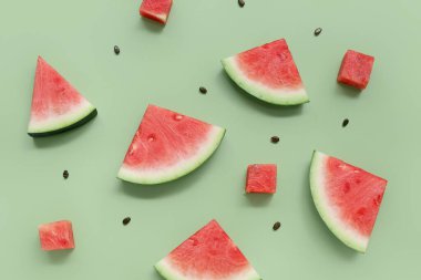 Taze karpuz parçaları ve yeşil arka planda tohumlar.