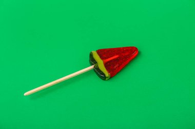 Yeşil arka planda karpuz dilimi şeklinde lolipop.