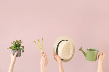 Pembe arka planda bitki ve farklı bahçe aletleri olan kadınlar.