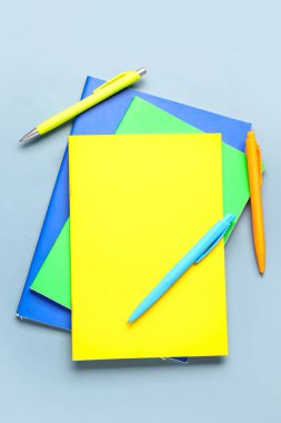 Gri arkaplanda renkli kalemleri olan defterler