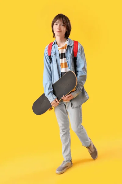 有黄色背景滑板的男生 — 图库照片