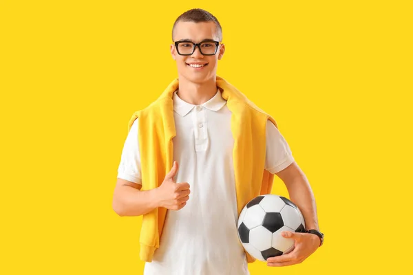 Studente Maschio Con Pallone Calcio Mostrando Pollice Sfondo Giallo — Foto Stock