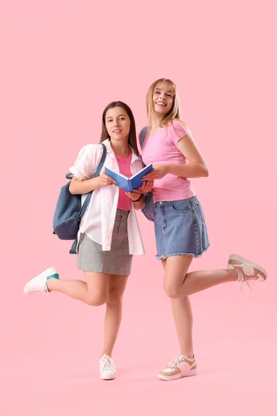Vrouwelijke Studenten Lezen Boek Roze Achtergrond — Stockfoto