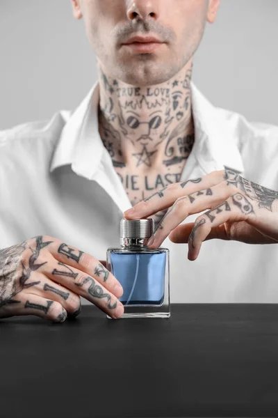 Tetovaný Mladý Muž Parfémem Stolu Světlém Pozadí Detailní Záběr — Stock fotografie