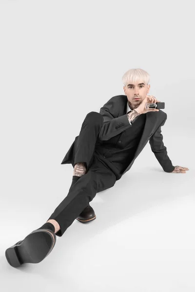 Tatuerad Ung Man Kostym Med Parfym Sitter Ljus Bakgrund — Stockfoto