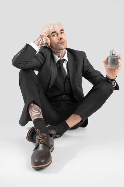 Tatuerad Ung Man Kostym Med Parfym Sitter Ljus Bakgrund — Stockfoto
