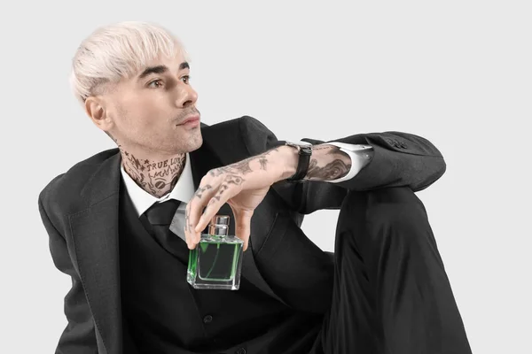 Tatuerad Ung Man Kostym Med Parfym Ljus Bakgrund — Stockfoto