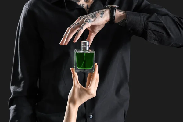 Getatoeëerde Jonge Man Vrouw Hand Met Parfum Donkere Achtergrond Close — Stockfoto