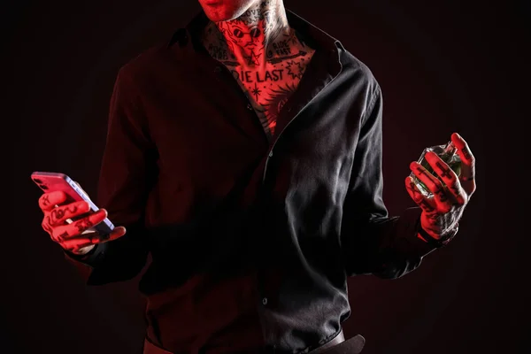 Tetovált Fiatalember Parfümmel Mobiltelefonnal Sötét Háttéren Közelkép — Stock Fotó