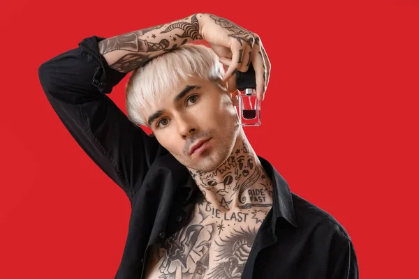 Tetovaný Mladý Muž Parfémem Červeném Pozadí Detailní Záběr — Stock fotografie