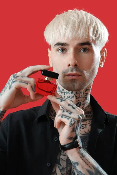 Tatuerad Ung Man Med Parfym Röd Bakgrund Närbild — Stockfoto