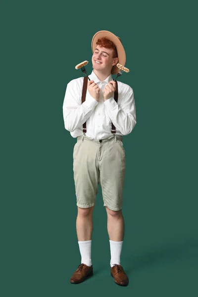 Junger Mann Traditioneller Deutscher Kleidung Mit Würstchen Auf Grünem Hintergrund — Stockfoto