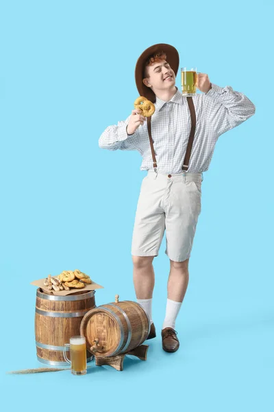 Молодий Чоловік Традиційному Німецькому Одязі Пивом Закусками Синьому Фоні — стокове фото