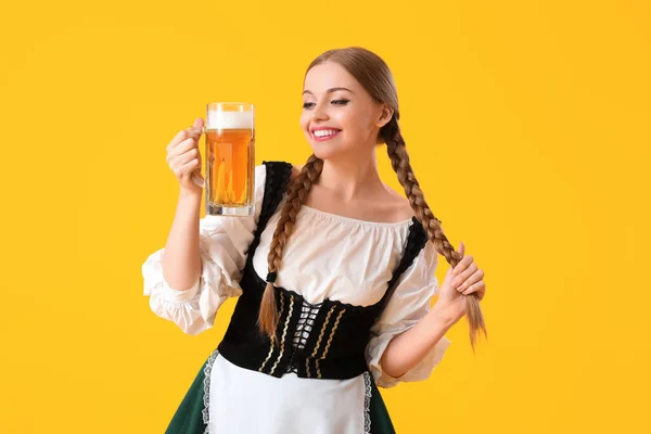 黄色の背景にビールと美しい10月の祭典のウェイトレス — ストック写真