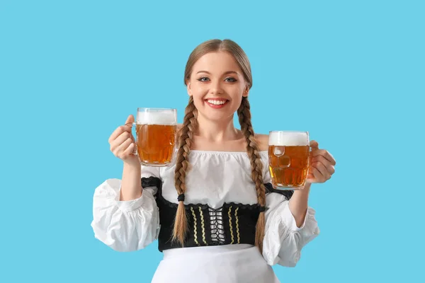 青い背景にビールと美しい10月の祭典のウエートレス — ストック写真