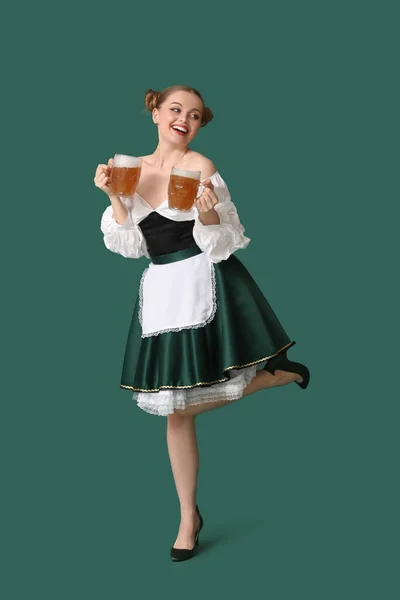 緑の背景でビールのダンスと美しい10月の祭典のウェイトレス — ストック写真