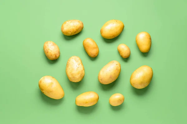 stock image Raw potatoes on green background