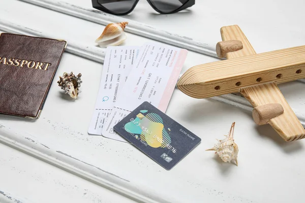 Összetétel Hitelkártyával Jegyekkel Fából Készült Repülőgéppel Kagylóval Könnyű Háttérrel — Stock Fotó