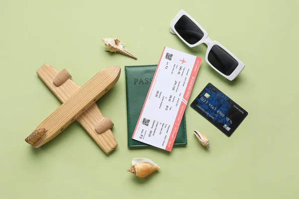 Kompozycja Biletem Kartą Kredytową Drewnianym Samolotem Okularami Przeciwsłonecznymi Zielonym Tle — Zdjęcie stockowe