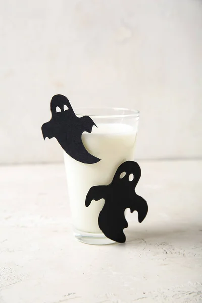 光を背景にハロウィン用の紙で作られたミルクと幽霊のガラス — ストック写真