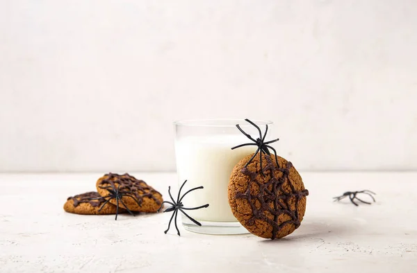 牛乳のガラス 光の背景にハロウィーンのためのおいしいクッキーとクモ クローズアップ — ストック写真