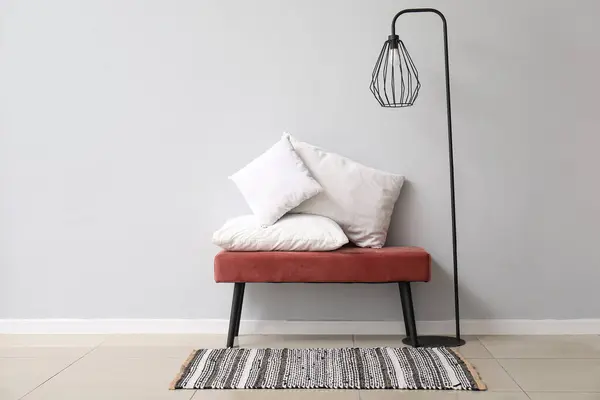 白い壁の近くの白い枕と標準的なランプのベンチ — ストック写真