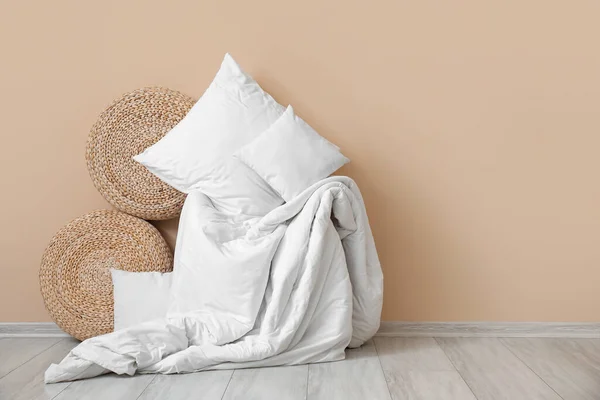 米色墙壁附近的白色枕头 毛毯和柳条袋 — 图库照片