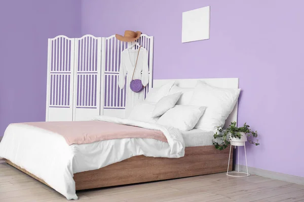 快適なベッド 白い枕と折りたたみ画面上のドレスを備えたスタイリッシュなベッドルームのインテリア — ストック写真