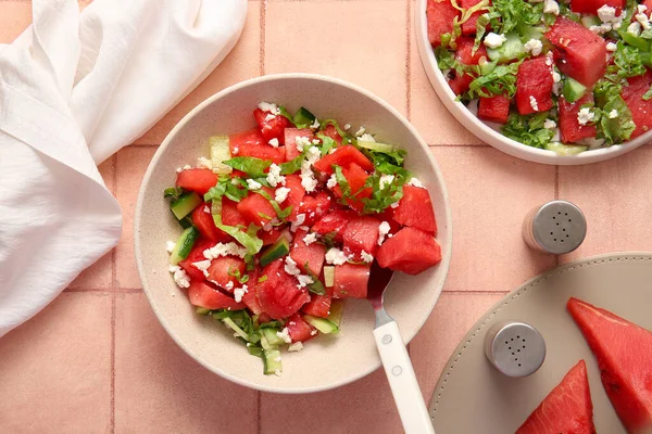 stock image Plate and bowl of tasty watermelon salad on beige tile background