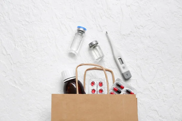 白いテクスチャの背景に異なる薬とショッピングバッグ — ストック写真