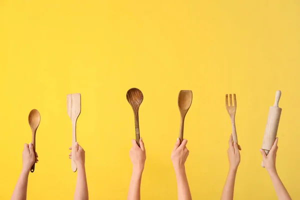 Sarı Arka Planda Ahşap Mutfak Aletleri Olan Kadın Eller — Stok fotoğraf