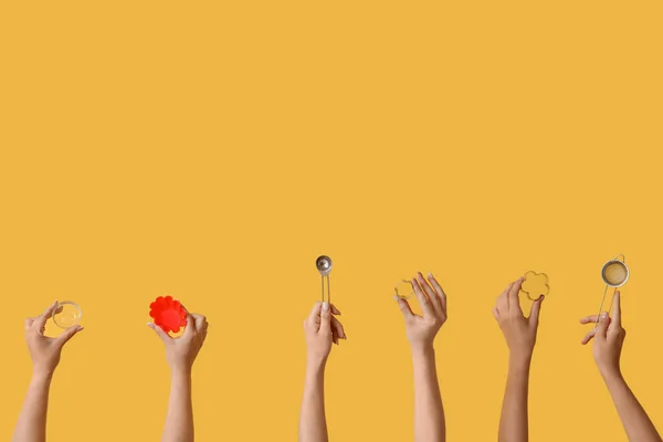 Weibliche Hände Mit Backutensilien Auf Gelbem Hintergrund — Stockfoto