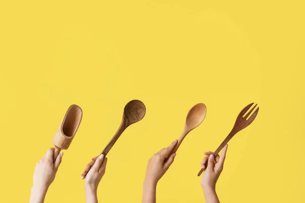 stock image Female hands with wooden baking utensils on yellow background