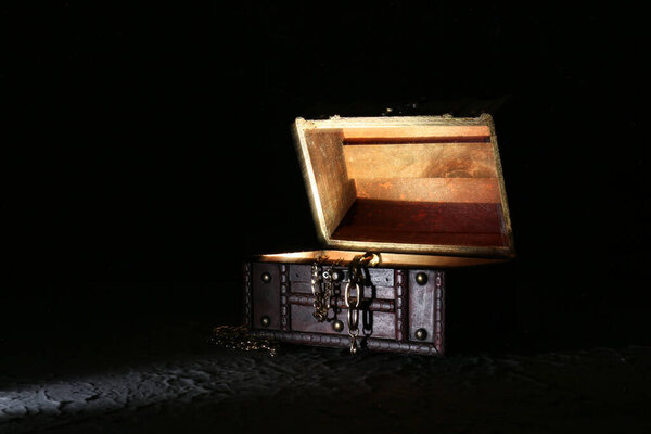 Decorative box with jewellery and glowing light on black background